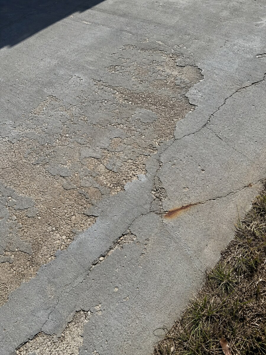 Spalling concrete driveway section showing exposed aggregate near the Jensen Beach coast
