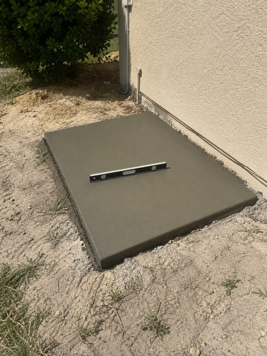 Small level concrete equipment pad poured beside a Florida home